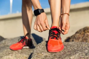 Person fastening red lace-up shoes before walking